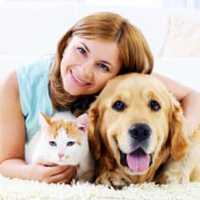 Happy pet owner with dog and cat